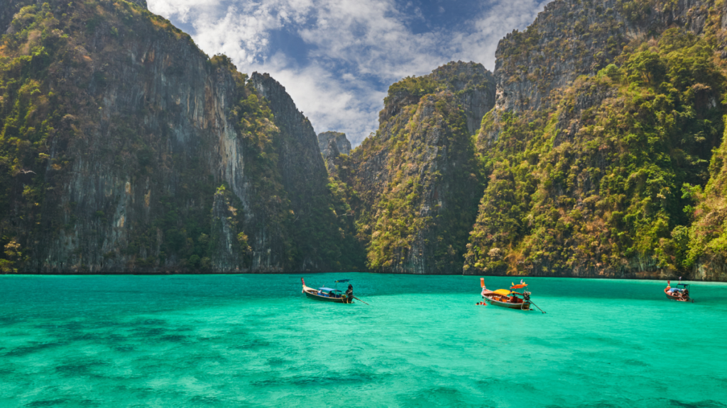 Dramatic karst formations frame the iconic turquoise water at Maya Bay, Phi Phi, Thailand